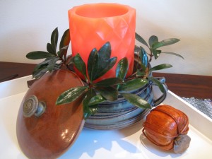 Orange candle with greenery